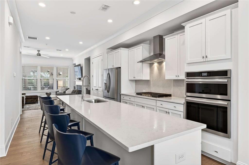6786 Encore Boulevard Atlanta, GA 30328 - Photo 5 of 31 a kitchen with stainless steel appliances a stove refrigerator sink and cabinets