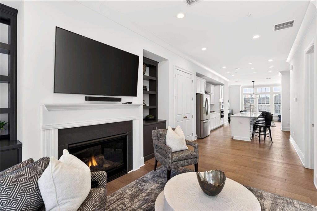 6786 Encore Boulevard Atlanta, GA 30328 - Photo 6 of 31 a living room with furniture a flat screen tv and a fireplace