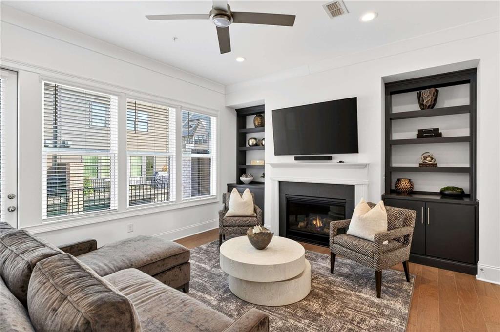 6786 Encore Boulevard Atlanta, GA 30328 - Photo 7 of 31 a living room with furniture a fireplace and a flat screen tv