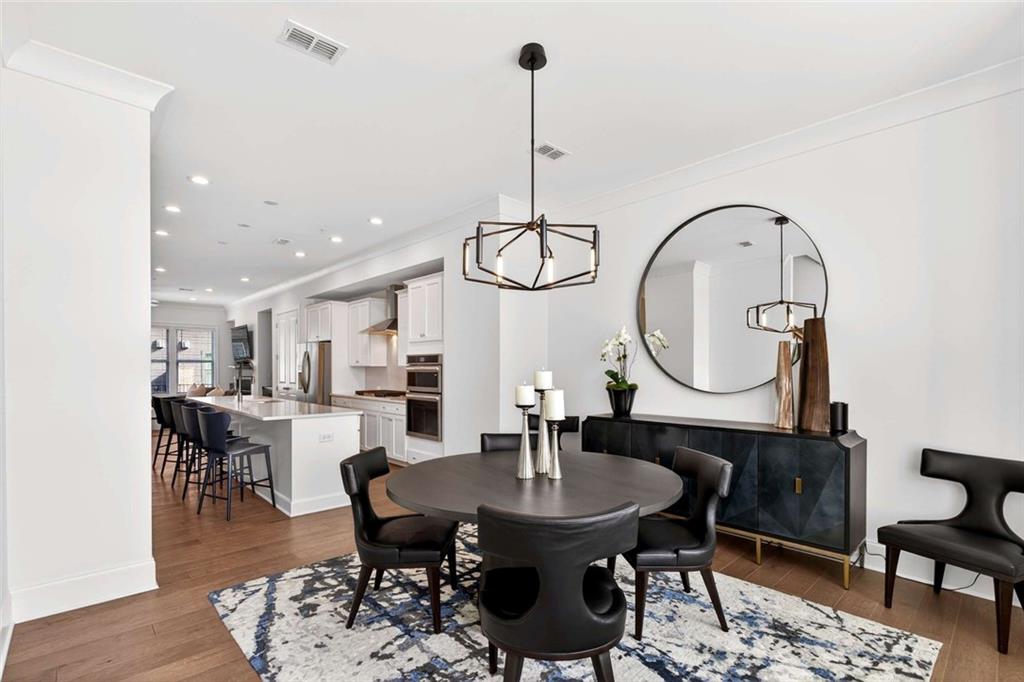 6786 Encore Boulevard Atlanta, GA 30328 - Photo 10 of 31 a dining room with furniture a rug and a chandelier