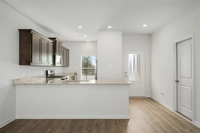 a kitchen with granite countertop cabinets stainless steel appliances and a window