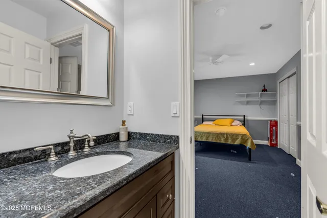a bathroom with a granite countertop sink a large mirror and a shower