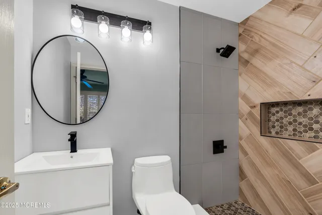 a bathroom with a granite countertop sink toilet and mirror
