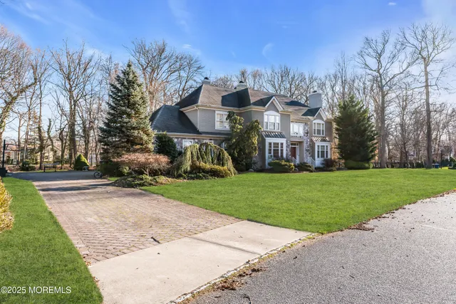 a view of a big house with a big yard and large trees