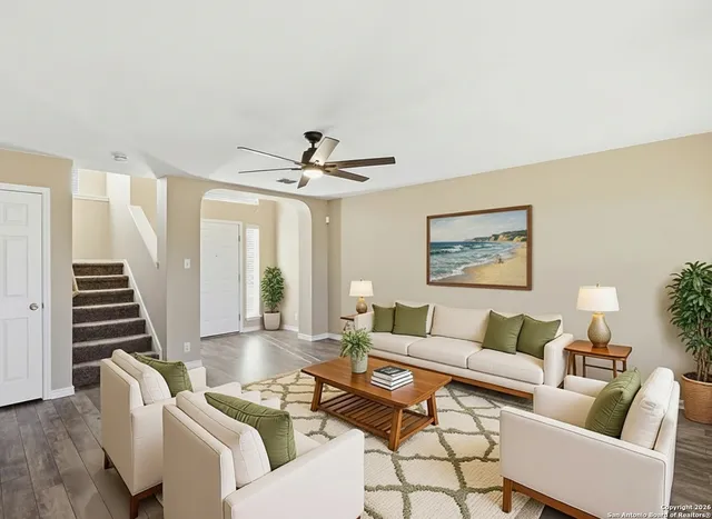 a living room with furniture and a ceiling fan