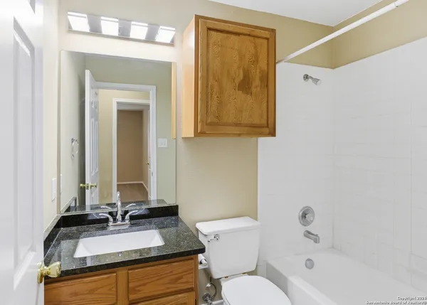 a bathroom with a granite countertop sink toilet and shower