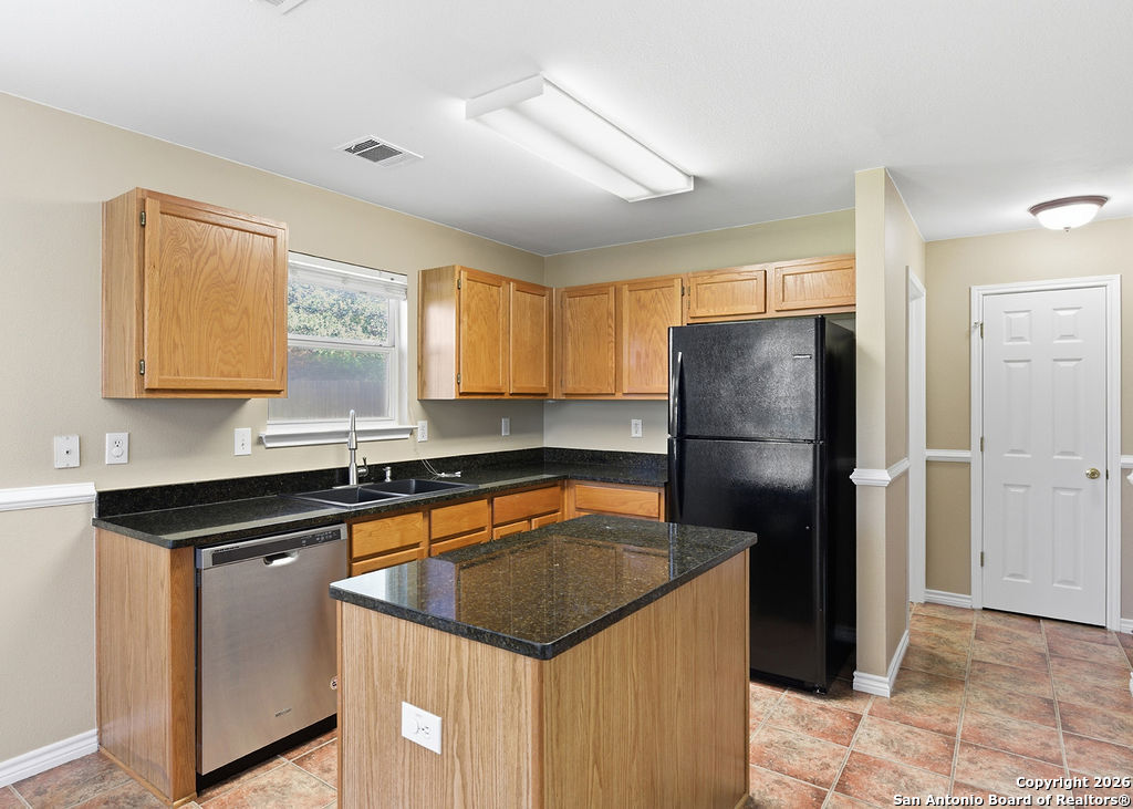 8905 Pinseeker Selma, TX 78154 - Photo 4 of 23 a kitchen with a refrigerator a sink and cabinets