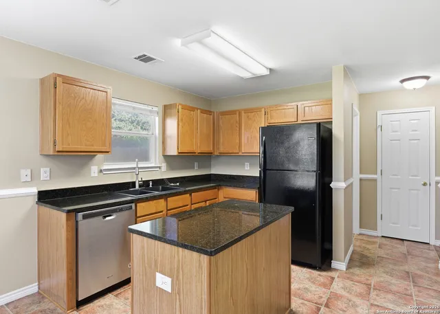 a kitchen with a refrigerator a sink and cabinets