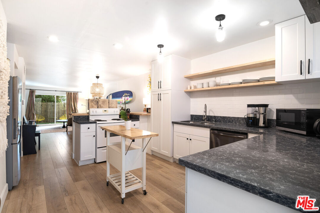 6479 Kanan Dume Road, Unit 24 Malibu, CA 90265 - Photo 8 of 22 a kitchen with stainless steel appliances granite countertop sink stove top oven and cabinets
