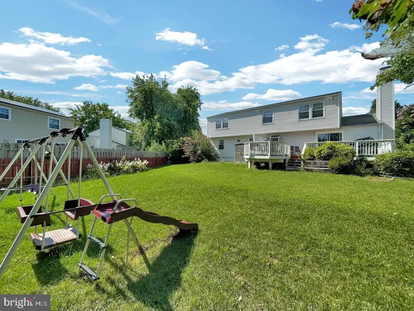 a view of a house with a yard and hanging chair