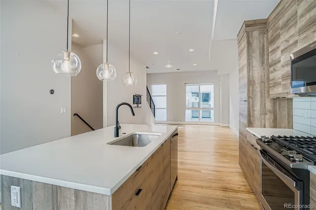a kitchen with kitchen island granite countertop a stove and a sink