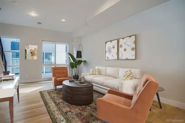 a living room with furniture a couch and a potted plant