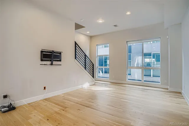 a view of a livingroom with wooden floor and windows