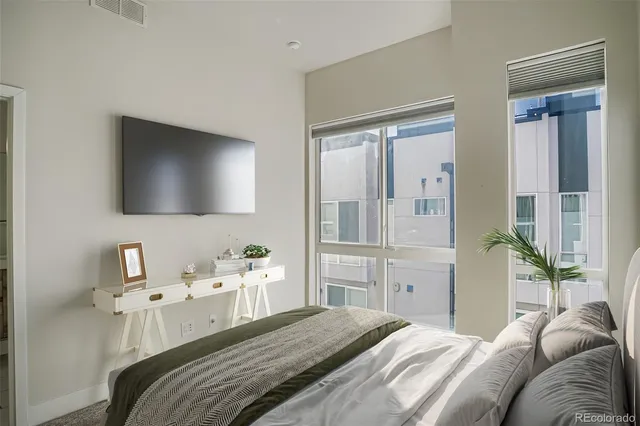 a bedroom with a bed and a flat tv screen