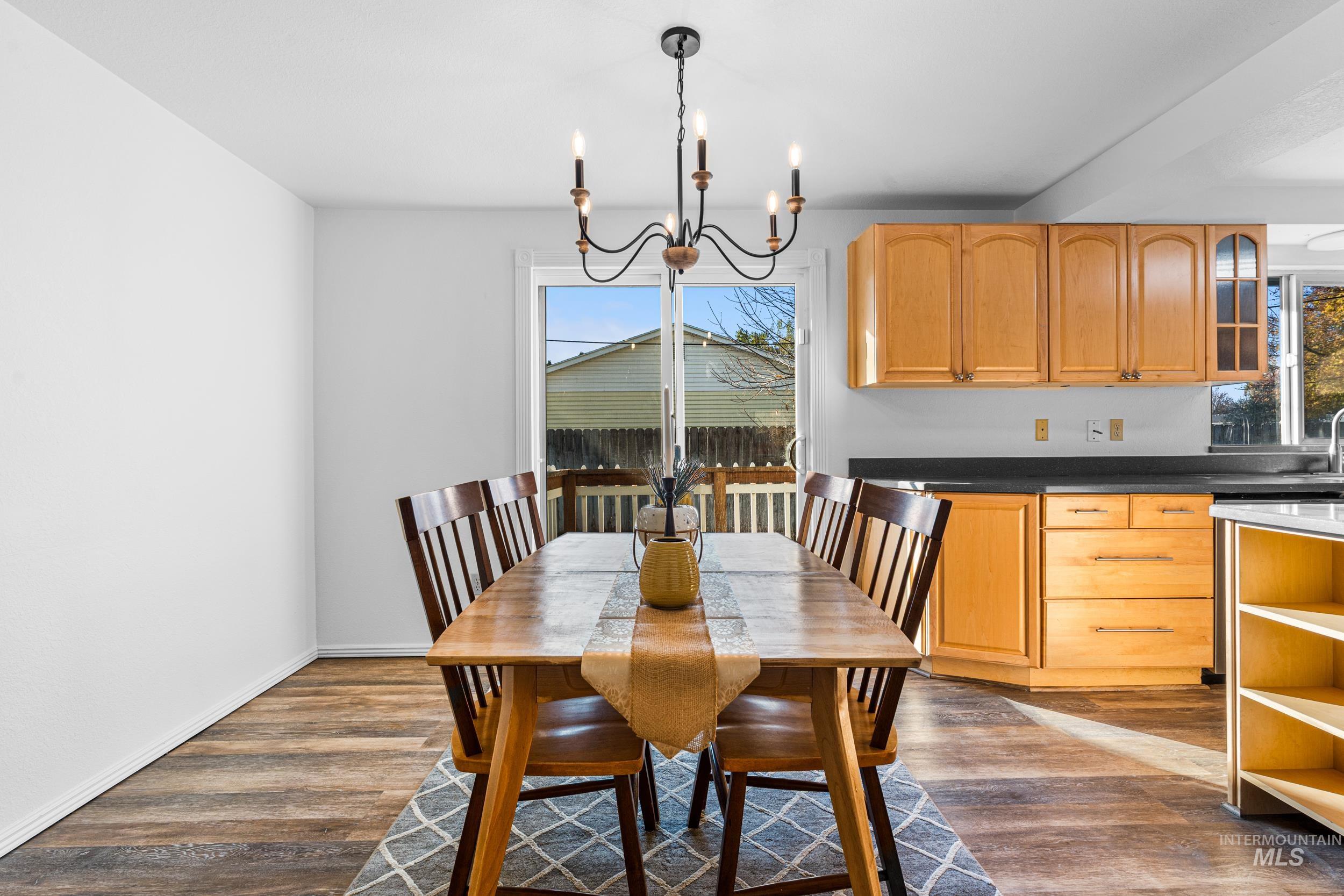 1212 East Ustick Road Caldwell, ID 83607 - Photo 12 of 50 Dining room featuring dark wood-style floors, healthy amount of natural light, and a chandelier