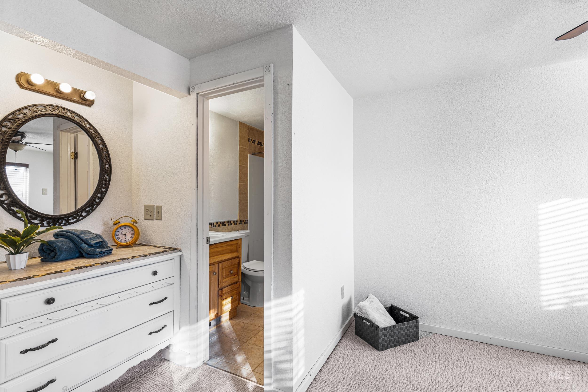 1212 East Ustick Road Caldwell, ID 83607 - Photo 16 of 50 Bathroom featuring a ceiling fan, vanity, a shower with shower curtain, light colored carpet, and a textured wall