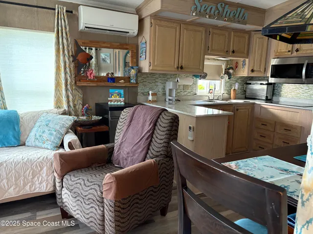 a living room with stainless steel appliances granite countertop furniture and a kitchen view