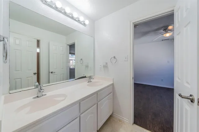 a bathroom with a double vanity sink mirror and shower