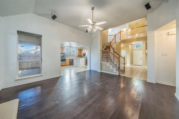a view of a livingroom with wooden floor and a ceiling fan