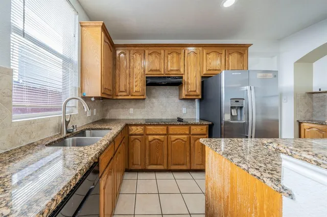 a kitchen with granite countertop a sink stainless steel appliances and cabinets