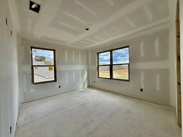 a view of an empty room with a window and fireplace