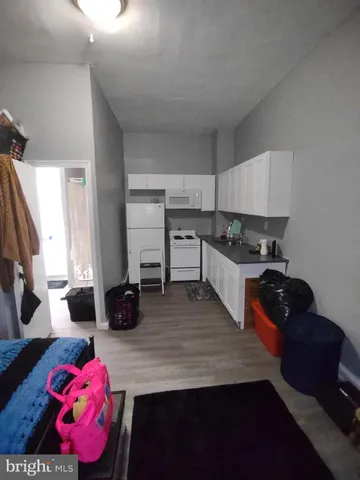 a kitchen with granite countertop a stove a sink dishwasher and cabinets with wooden floor