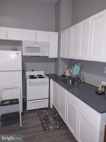 a kitchen with a white cabinets and white appliances