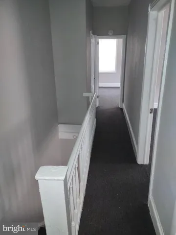 a view of a hallway with wooden floor and stairs