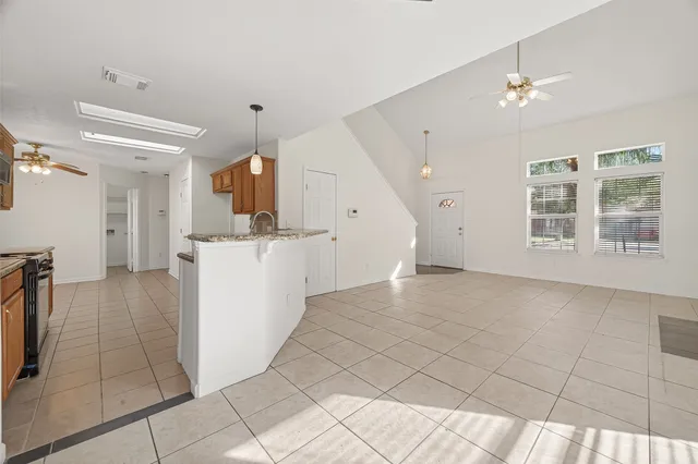 an empty room with a chandelier fan