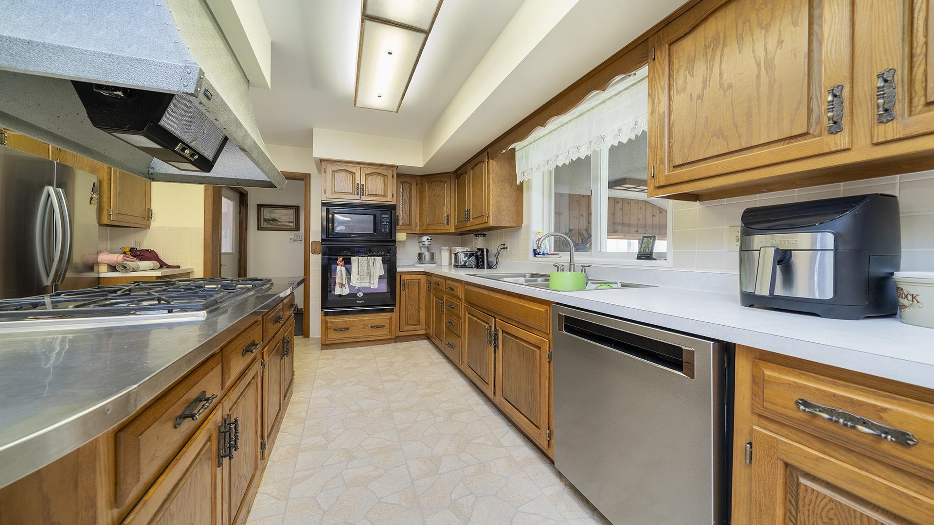 10245 West Penn Corner Road Polo, IL 61064 - Photo 13 of 48 a large kitchen with stainless steel appliances granite countertop a stove a sink dishwasher and cabinets with wooden floor