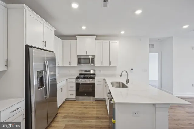 a kitchen with stainless steel appliances granite countertop a refrigerator sink and stove