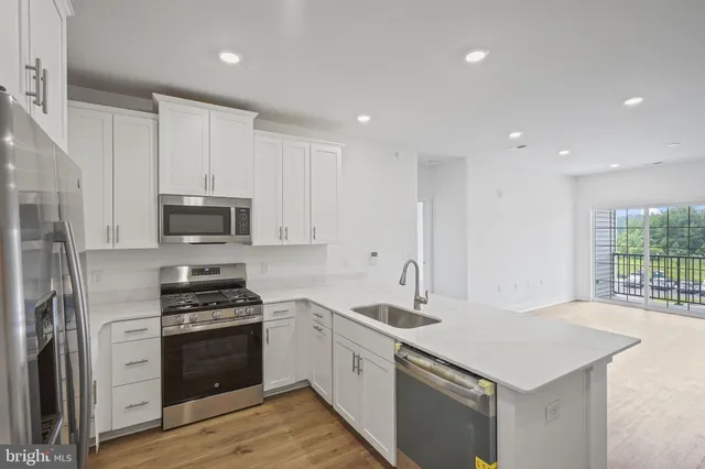 a kitchen with stainless steel appliances a sink stove and refrigerator