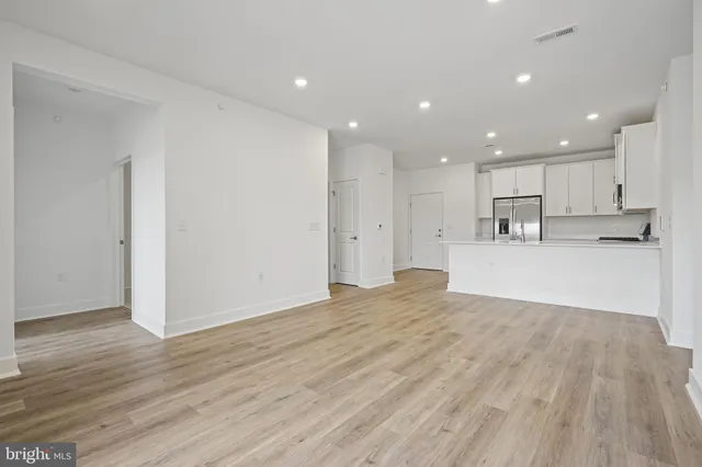 a view of kitchen with kitchen island wooden floor center island and stainless steel appliances
