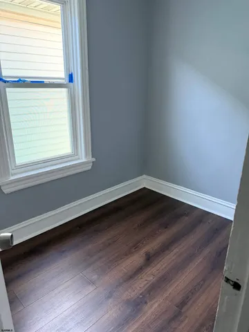 a view of a room that has wooden floor and a window