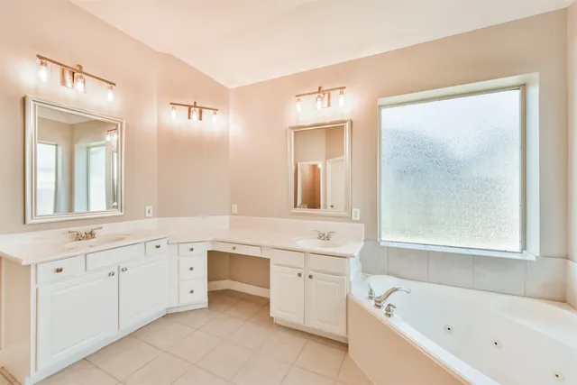 a bathroom with a bathtub sink and mirror