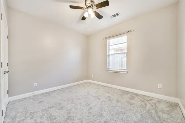 an empty room with a window and a fan
