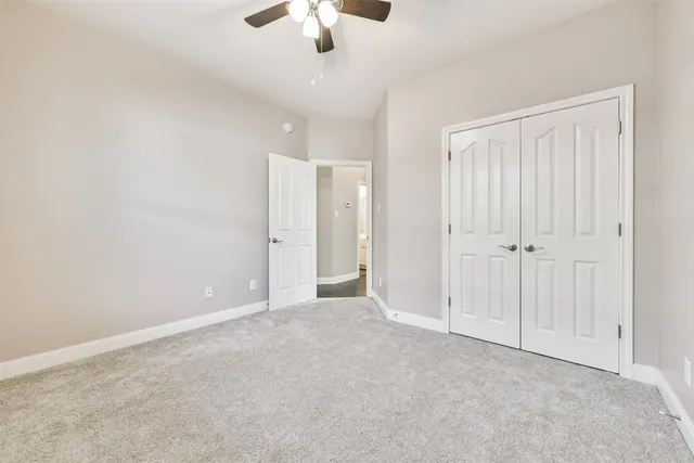 an empty room with chandelier fan