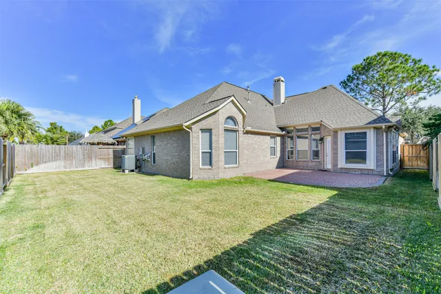 a view of a house with backyard and a tree