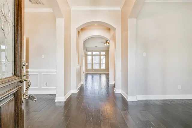 a view of a hallway with wooden floor and cabinet