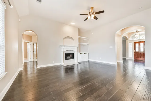 a view of empty room with a fireplace and wooden floor