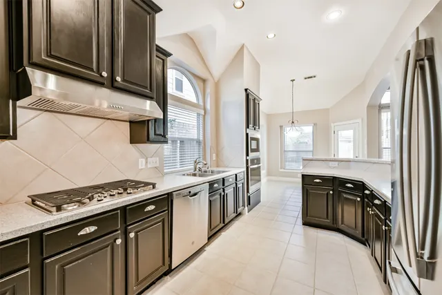 a kitchen with stainless steel appliances a sink stove and cabinets