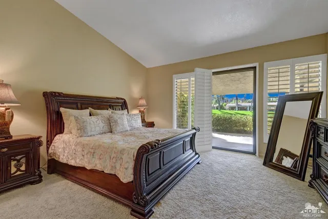 a bedroom with a bed a fireplace and a large window