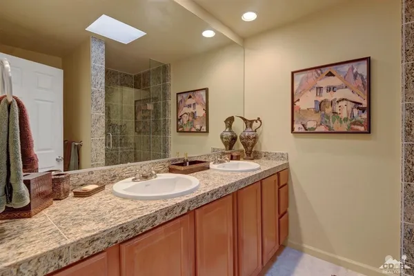 a bathroom with a granite countertop double vanity sink and a mirror