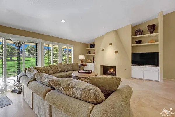 a living room with furniture large window and a flat screen tv
