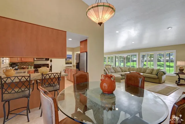 a living room with furniture a chandelier and a large window
