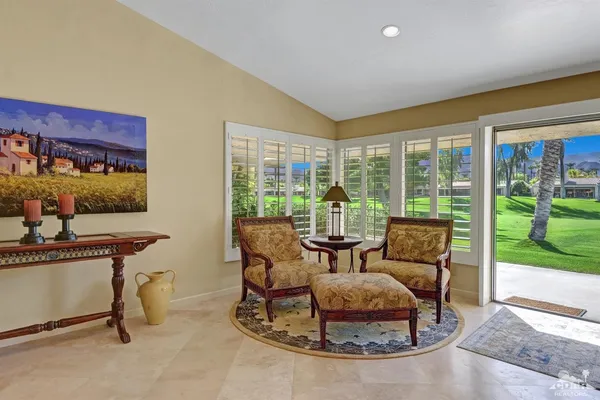 a living room with furniture and a floor to ceiling window
