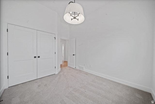 1117 East Shilow Road, Unit 106 Erda, UT 84074 - Photo 13 of 21 Spacious room featuring light gray carpeting, tall white baseboards, and a contemporary ceiling light fixture