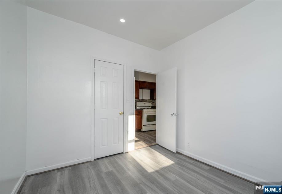 49 River Street, Unit 2 Lodi, NJ 07644 - Photo 11 of 24 a view of an empty room with wooden floor and closet