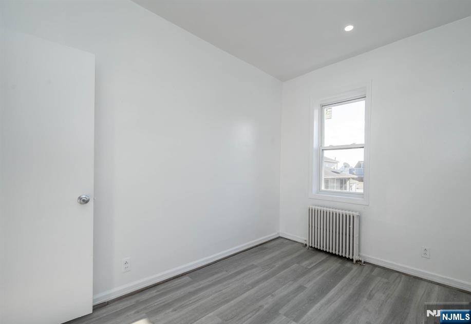 49 River Street, Unit 2 Lodi, NJ 07644 - Photo 12 of 24 an empty room with wooden floor and windows