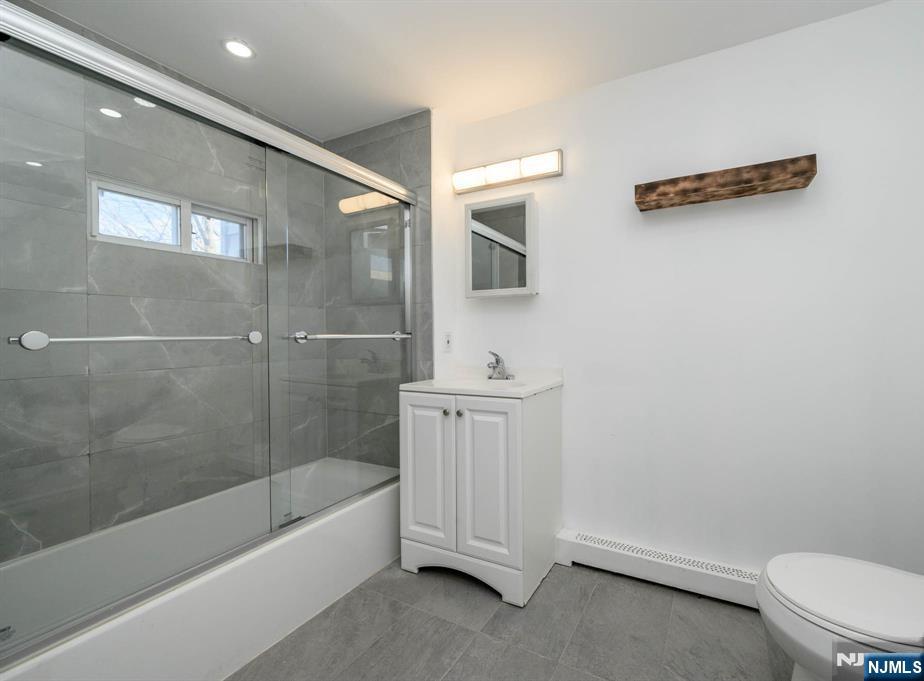 49 River Street, Unit 2 Lodi, NJ 07644 - Photo 13 of 24 a bathroom with a sink a toilet and bathtub